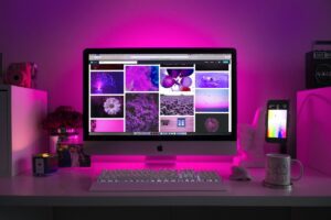 Computer on desktop in purple light